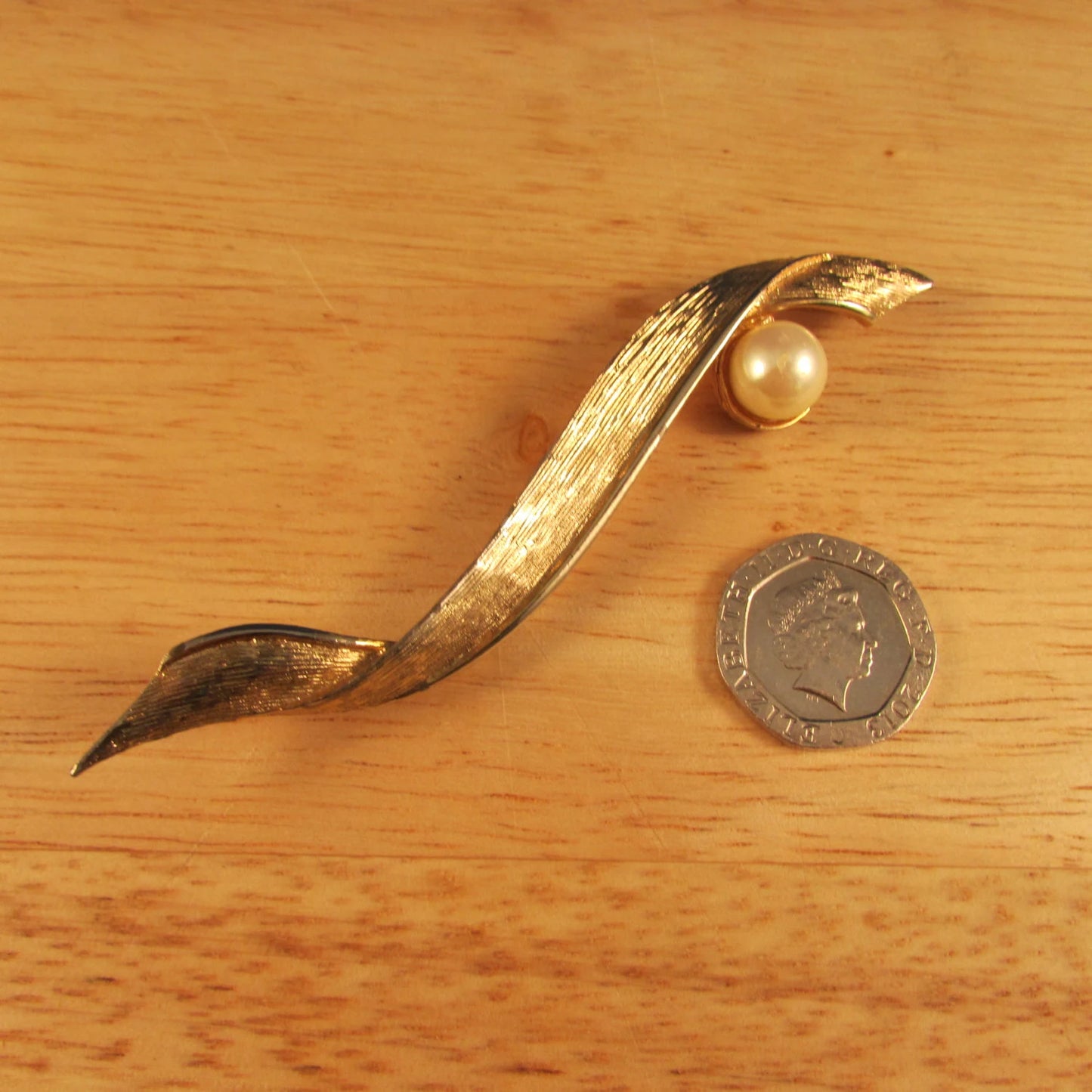 Large vintage gold-tone ribbon brooch with faux pearl