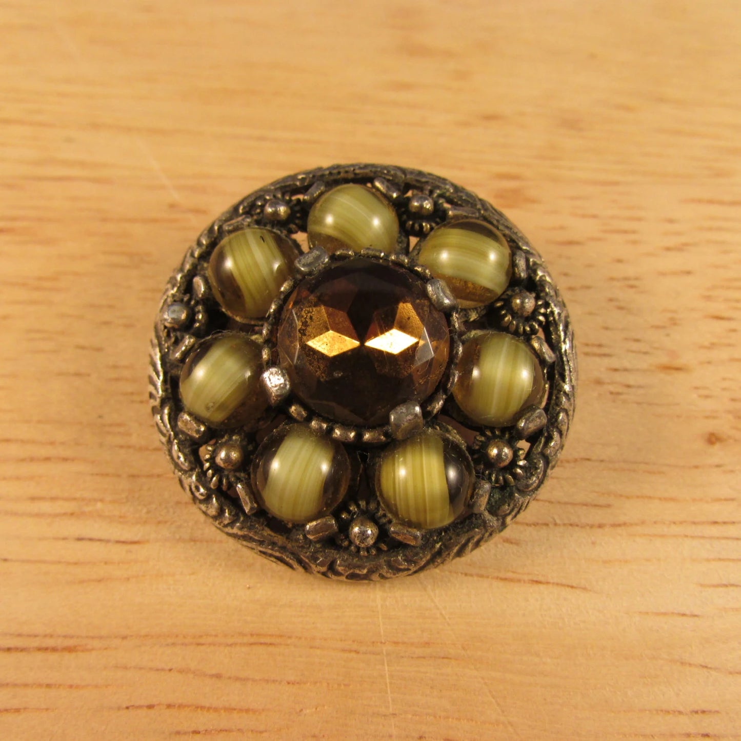 1970s round Celtic-style pendant/brooch, polished green stones with citrine centre, stamped MIRACLE