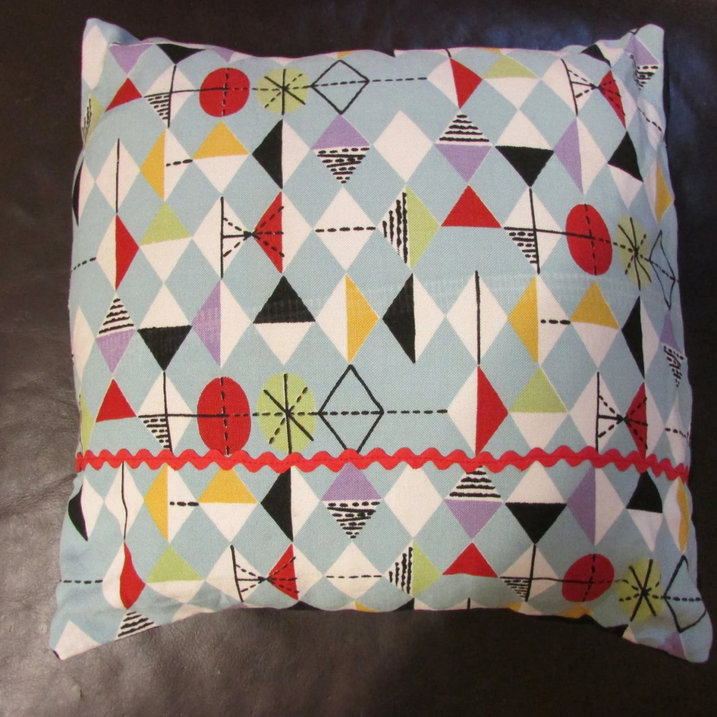 Home-made mid-century Marian Mahler atomic fabric cushion with red ric-rac, and contrast black reverse