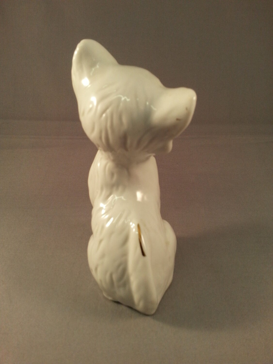 circa. 1960s kitsch white kitten ornament with blue bow
