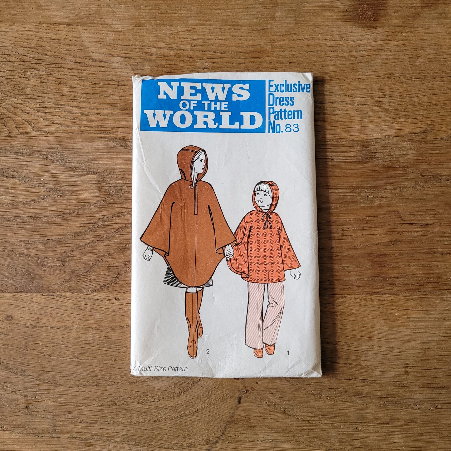Uncut 1970s News of The World No.83 sewing pattern for hooded poncho, sizes 3/4 years to 9/10 years (complete)
